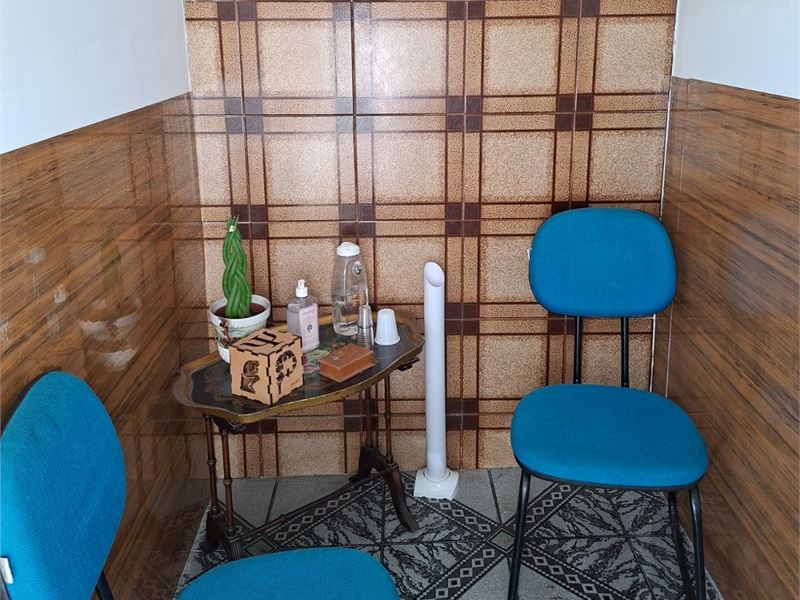Sala de espera com cadeiras e mesa de apoio